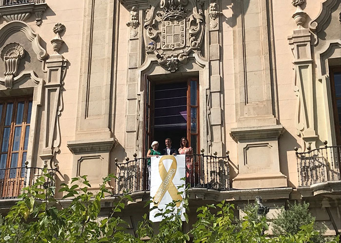 Un lazo dorado como símbolo de esperanza para los niños con cáncer cuelga de la fachada del Ayuntamiento de Jaén